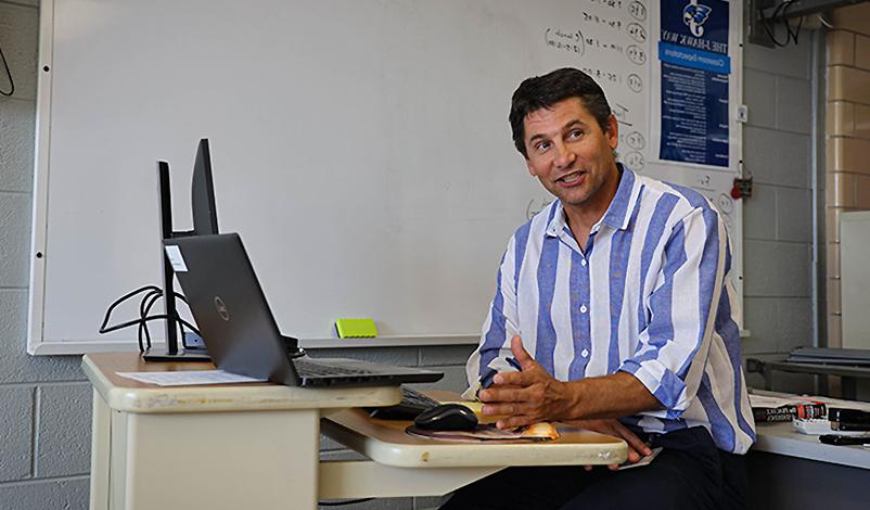 Terry sitting at his desk, explaining math concepts